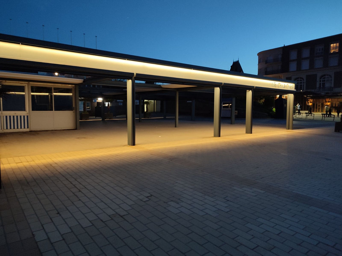 Terrasse couverte du Glacier à Dinard éclairée de nuit par la pergola